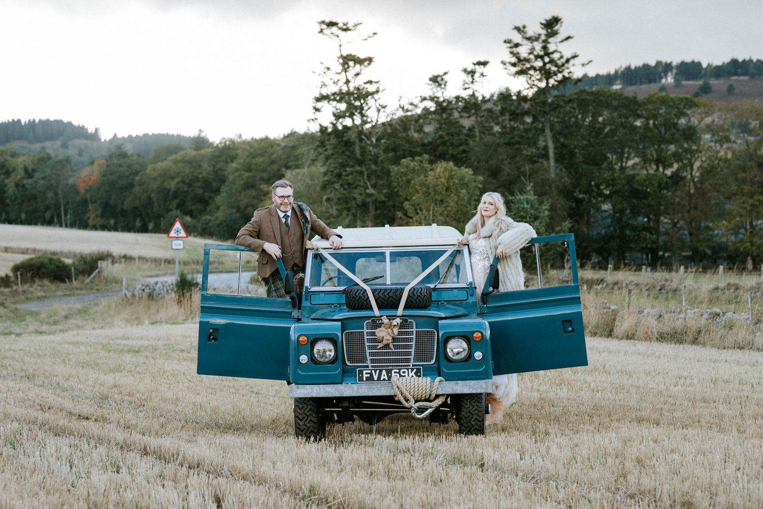 Vintage blue pickup truck parked in a scenic field during a wedding photoshoot.