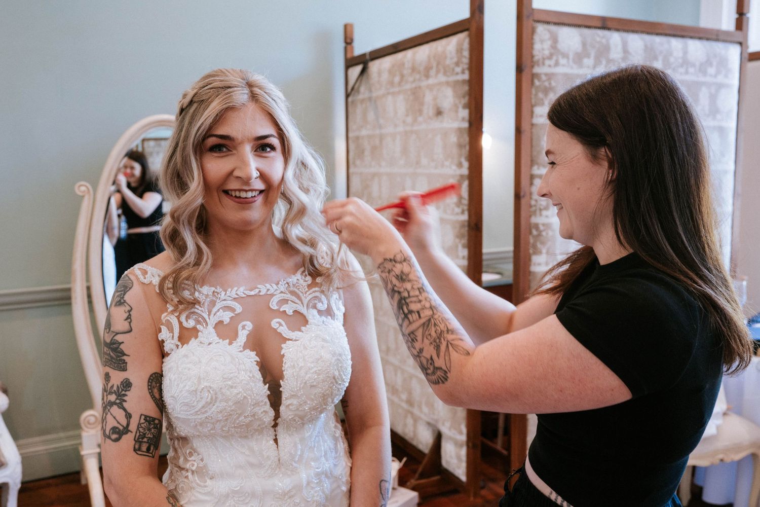 A stylist puts finishing touches on a bridal look in an elegant dressing room.