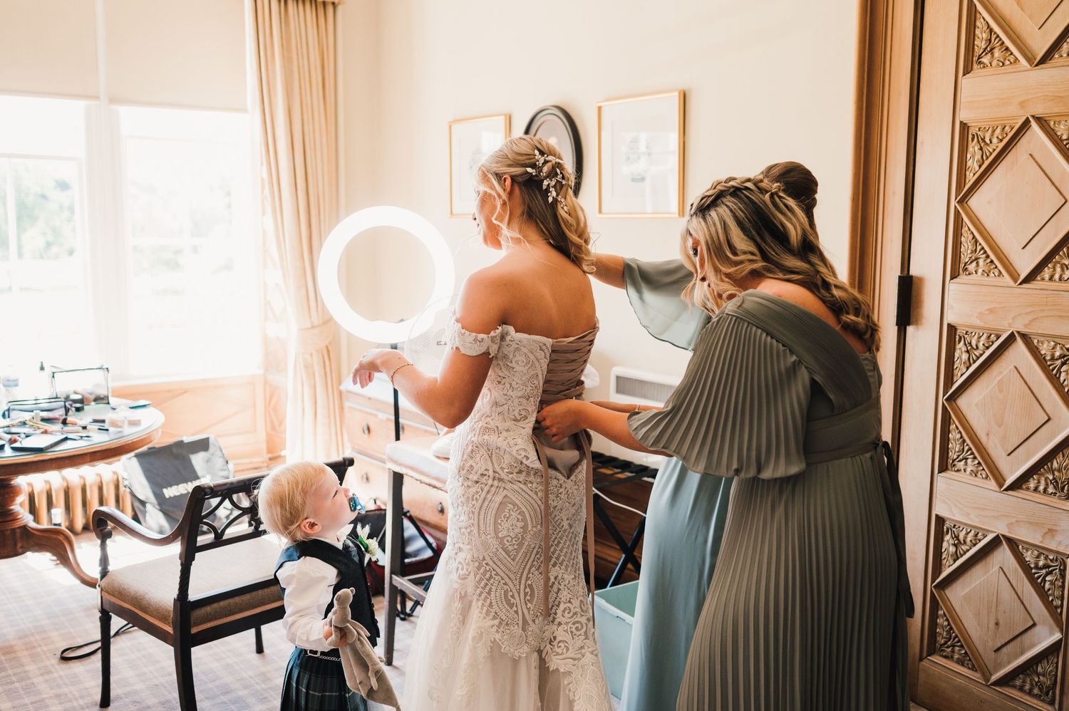 Natural light streams through window as final wedding preparations take place.
