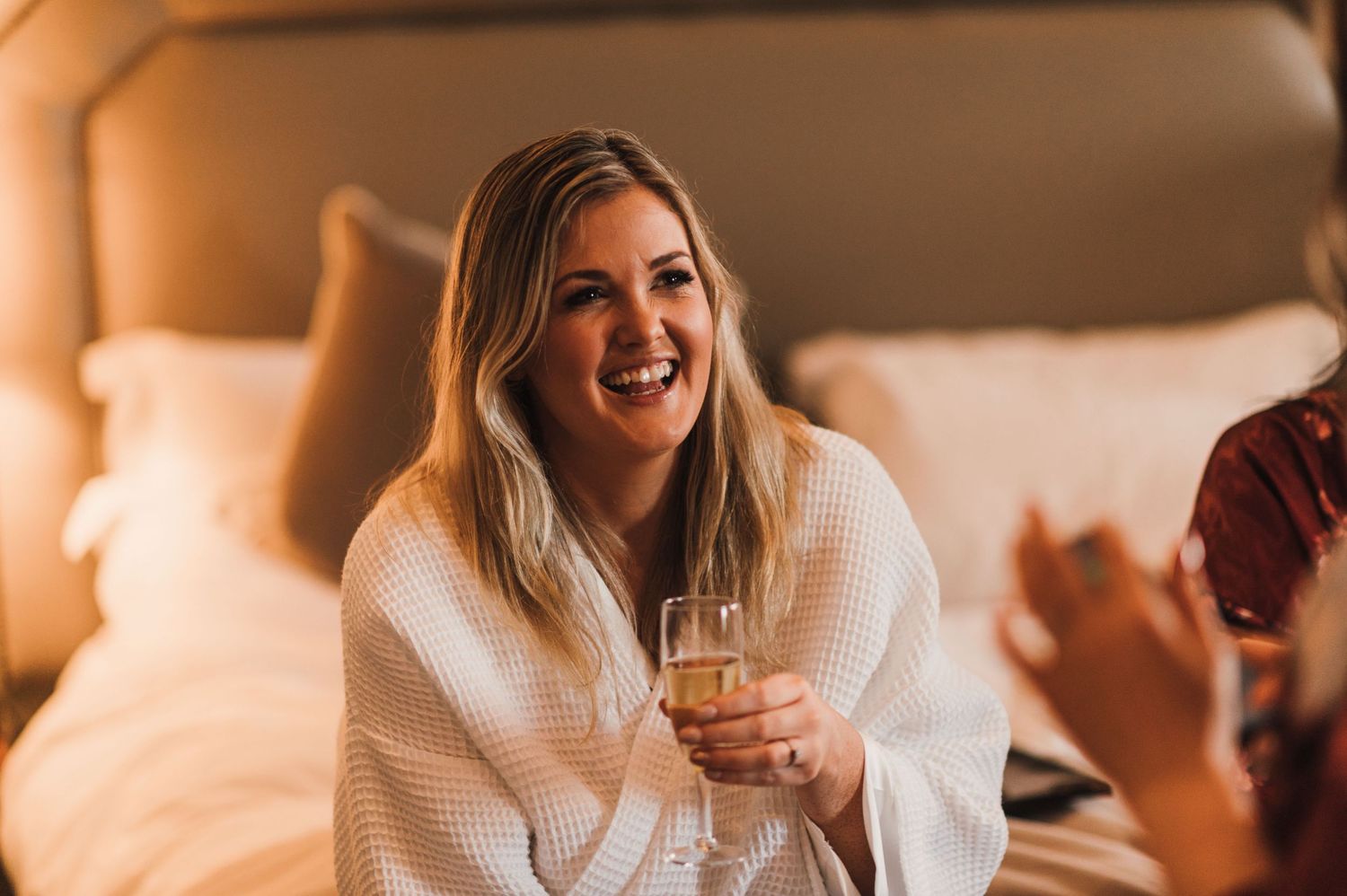 A candid moment of laughter during pre-wedding preparations in a hotel room.
