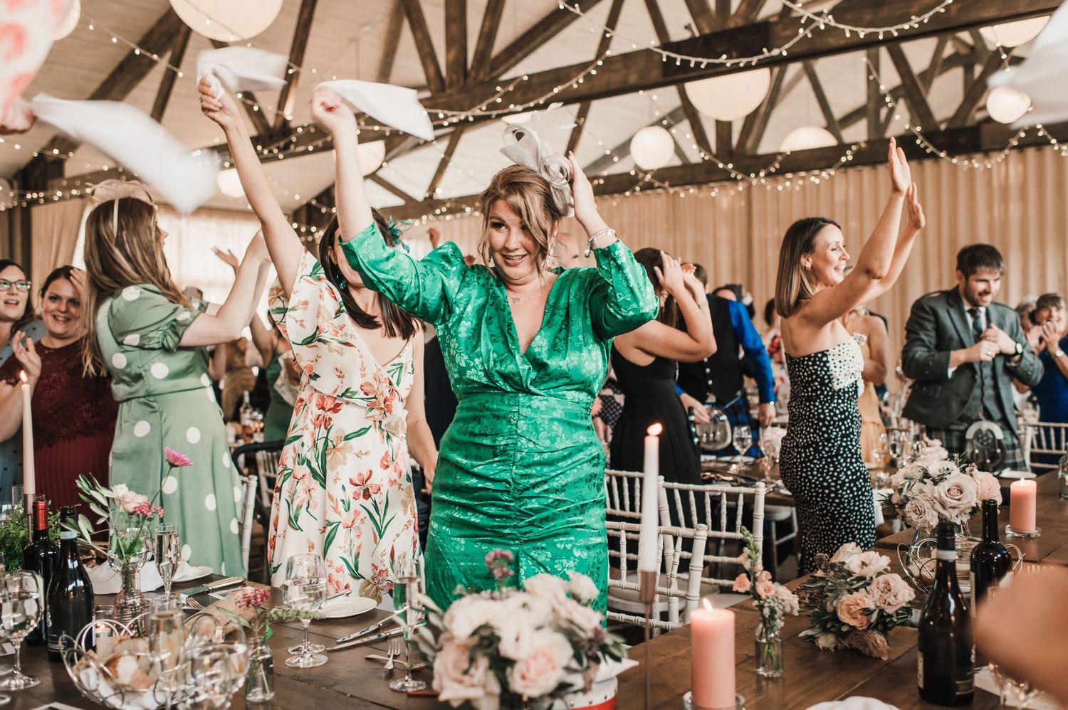 Wedding reception celebration with guests dancing and enjoying festivities in decorated venue.