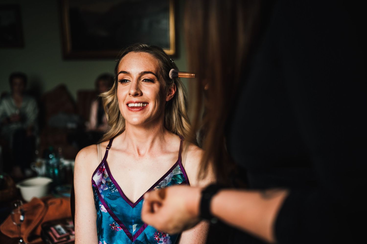 A candid moment captured during wedding preparations with warm lighting and a festive atmosphere.