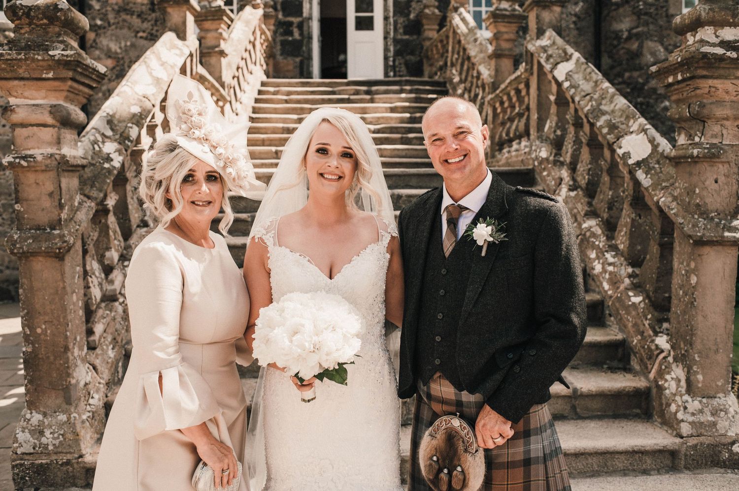 Wedding party members share a joyful moment on decorative stone steps.