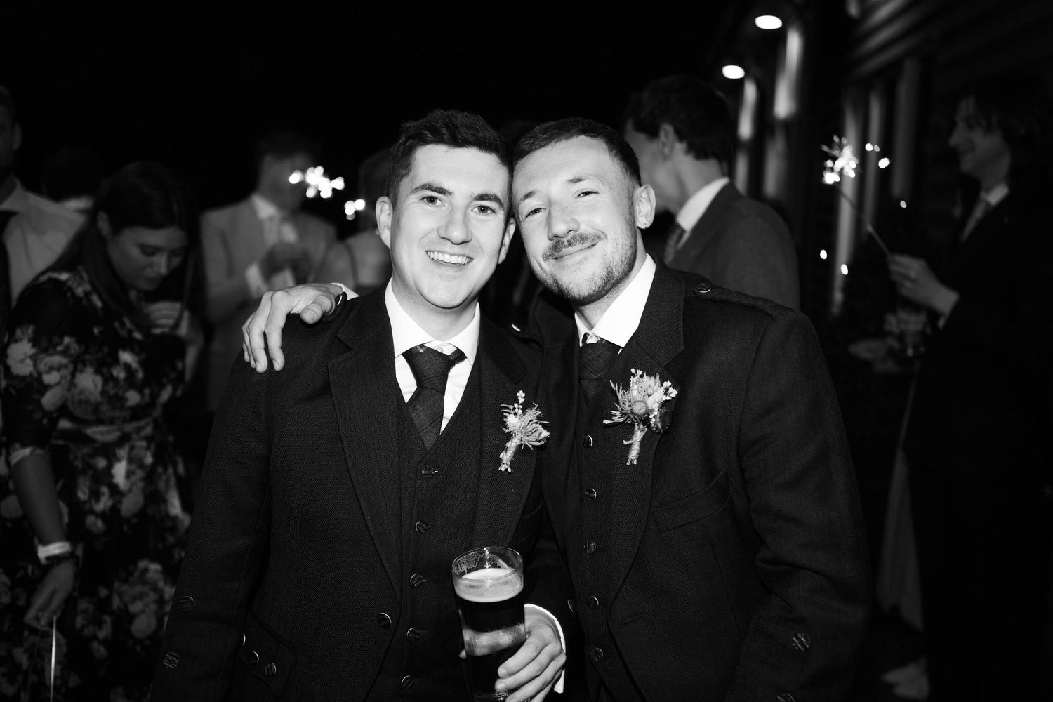 Black and white candid shots of wedding guests celebrating at an evening reception.
