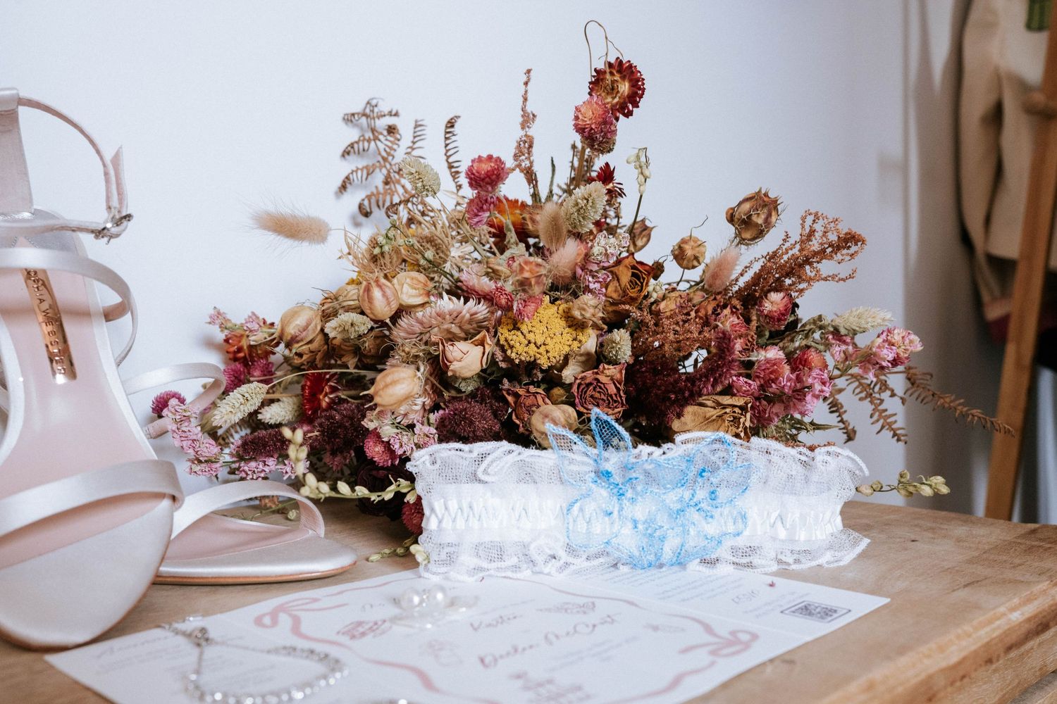 Dried floral arrangements in muted autumn colors displayed on a white tablecloth.