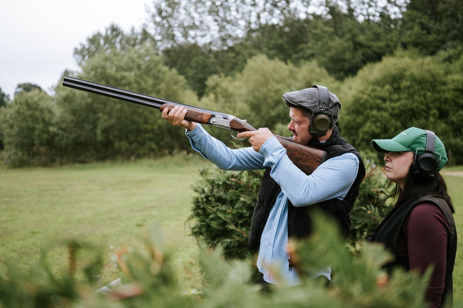 Group clay pigeon shooting activity outdoors in a green field.