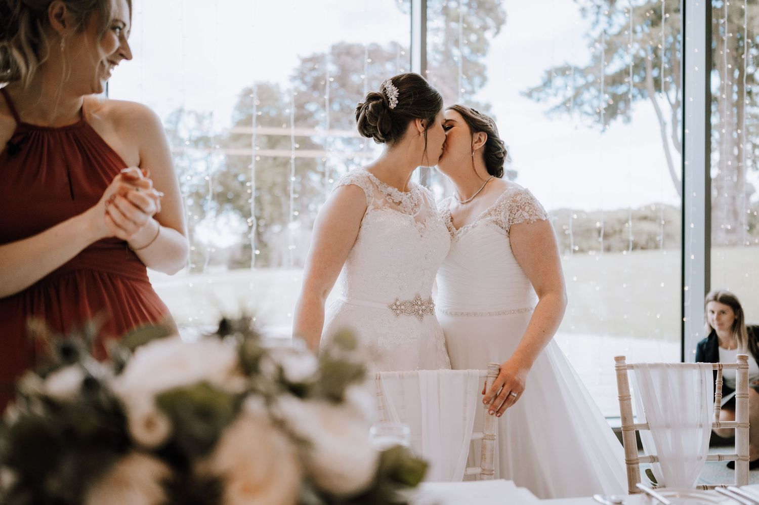 Wedding celebration in a bright reception room with floor-to-ceiling windows. Meldrum House Wedding Photography.