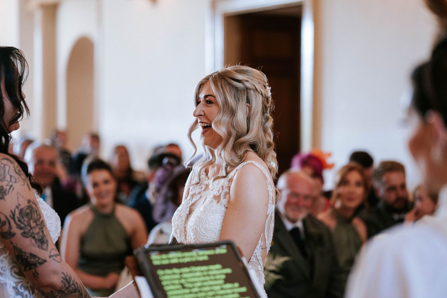 Fasque Castle Wedding Photography. Wedding guests seated in rows watching ceremony in elegant white venue.