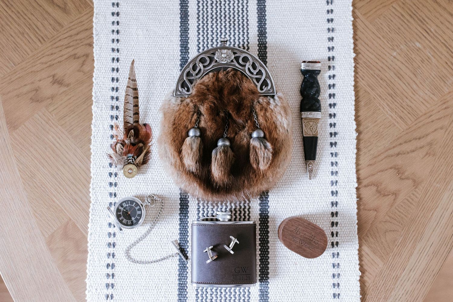 Overhead view of a striped table runner on a wooden floor with decorative elements.