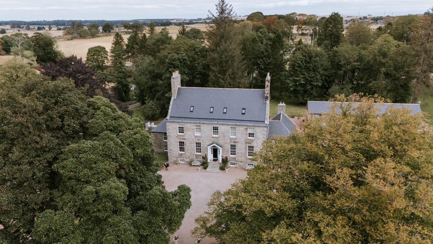 Aerial panoramic view of a countryside estate with historic buildings and lush green surroundings.