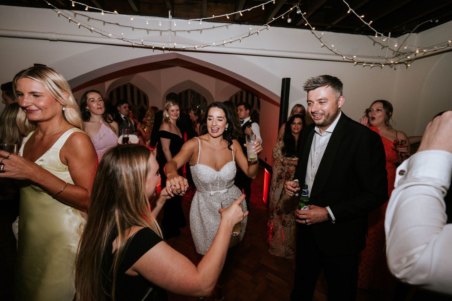 Lively dance floor scene at a wedding reception with guests enjoying the celebration.
