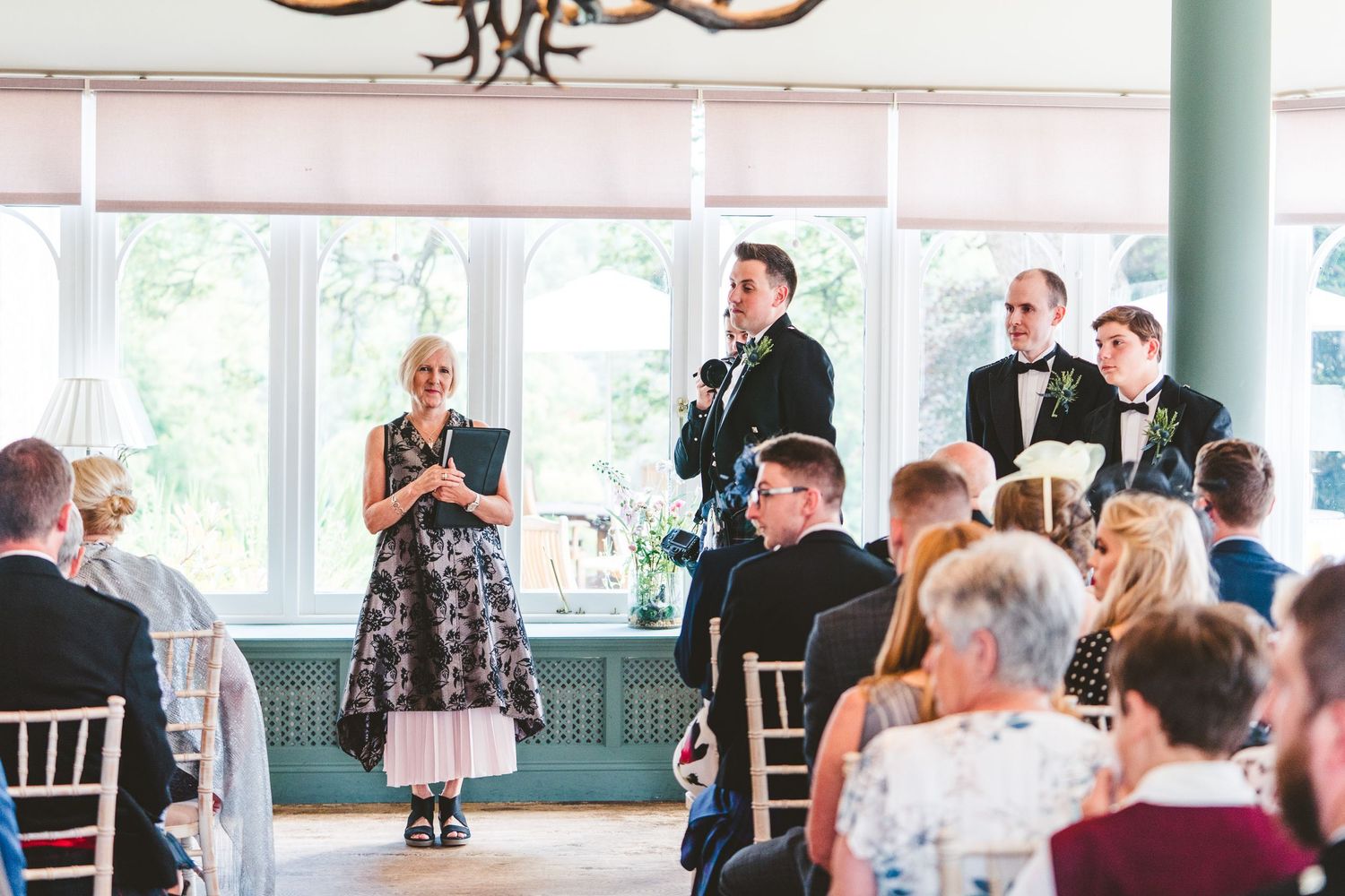 Wedding reception venue with elegant chandelier and chiavari chairs set up for guests.
