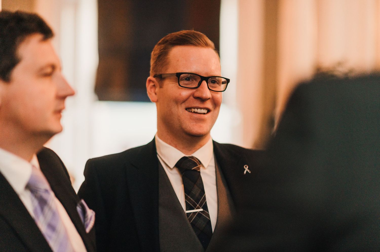 A candid moment shows guests sharing laughter during a formal event.