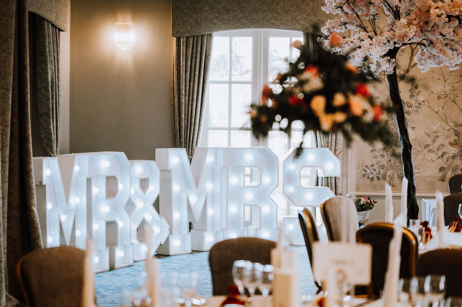 Illuminated 'Mr & Mrs' sign display at an elegant wedding reception venue.