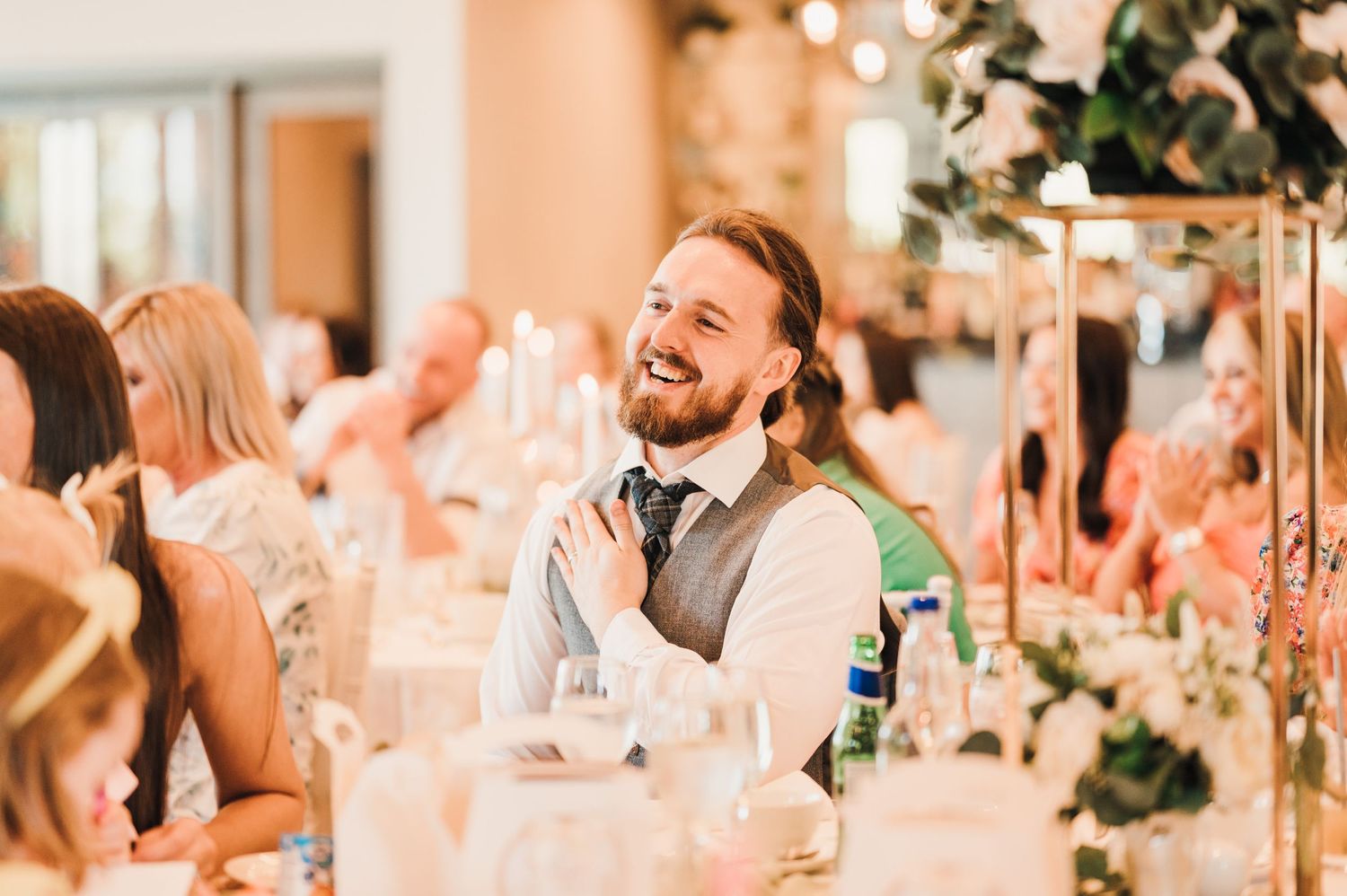 Guest enjoying conversation and laughter during elegant wedding reception dinner.