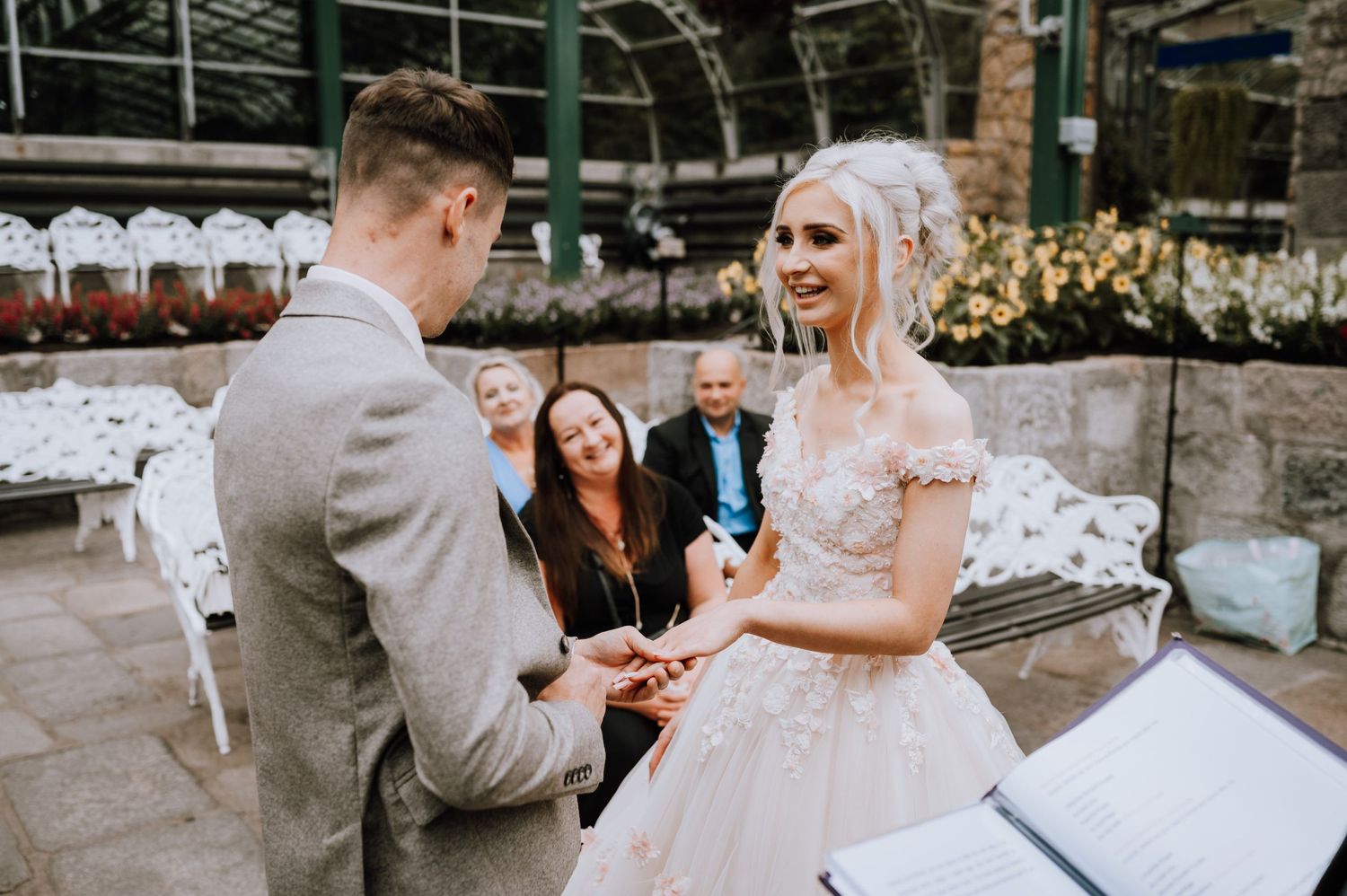 Exchange of rings during an intimate garden wedding ceremony.