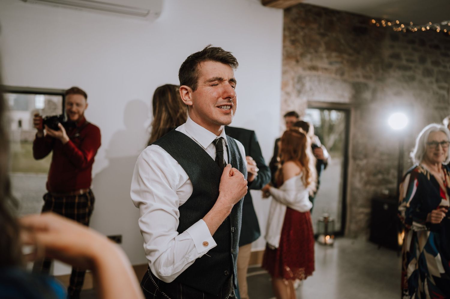 A celebration moment captured during a wedding reception in an industrial-style venue.