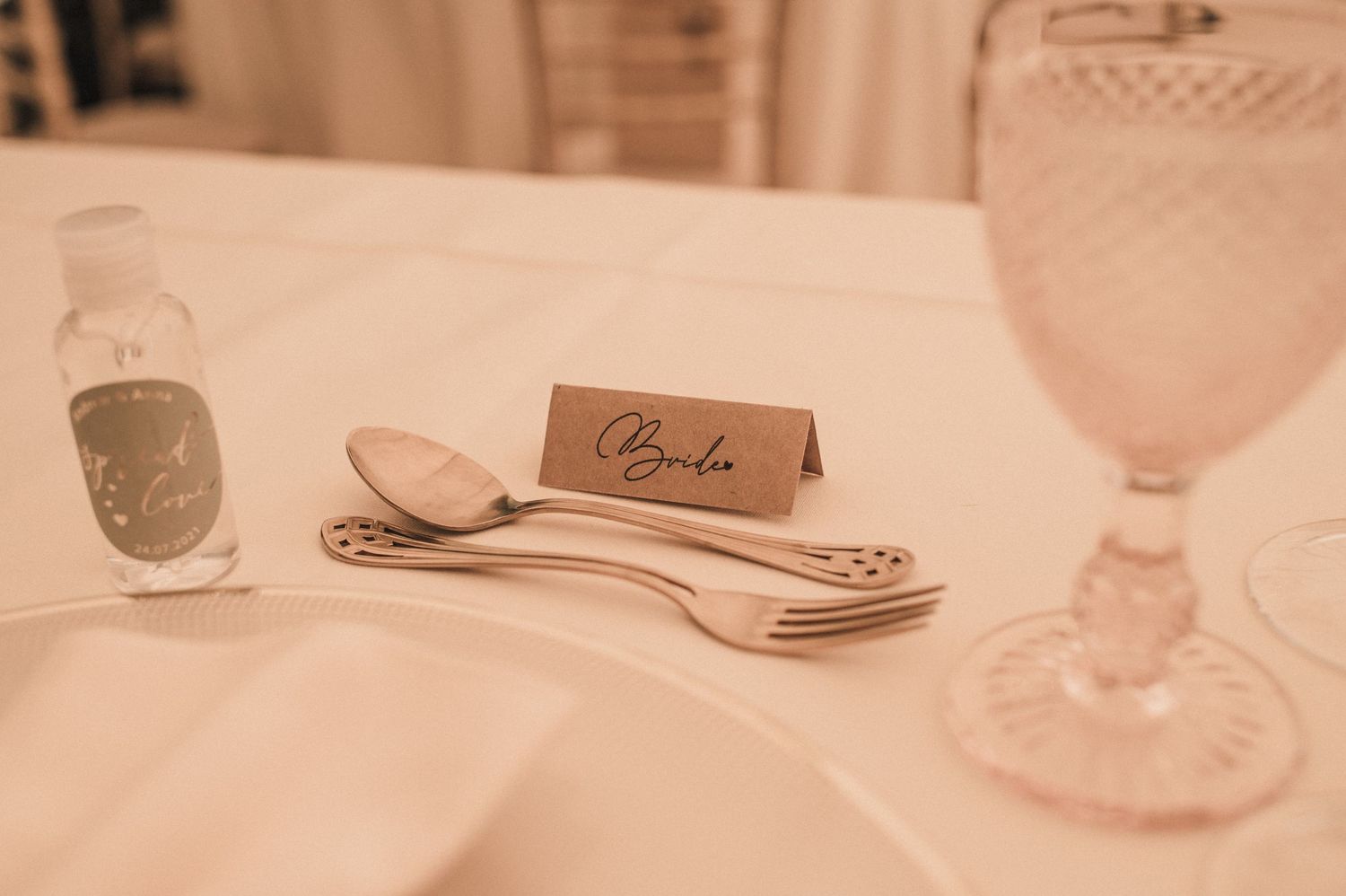 Elegant table setting with name card, silverware, and crystal glasses.