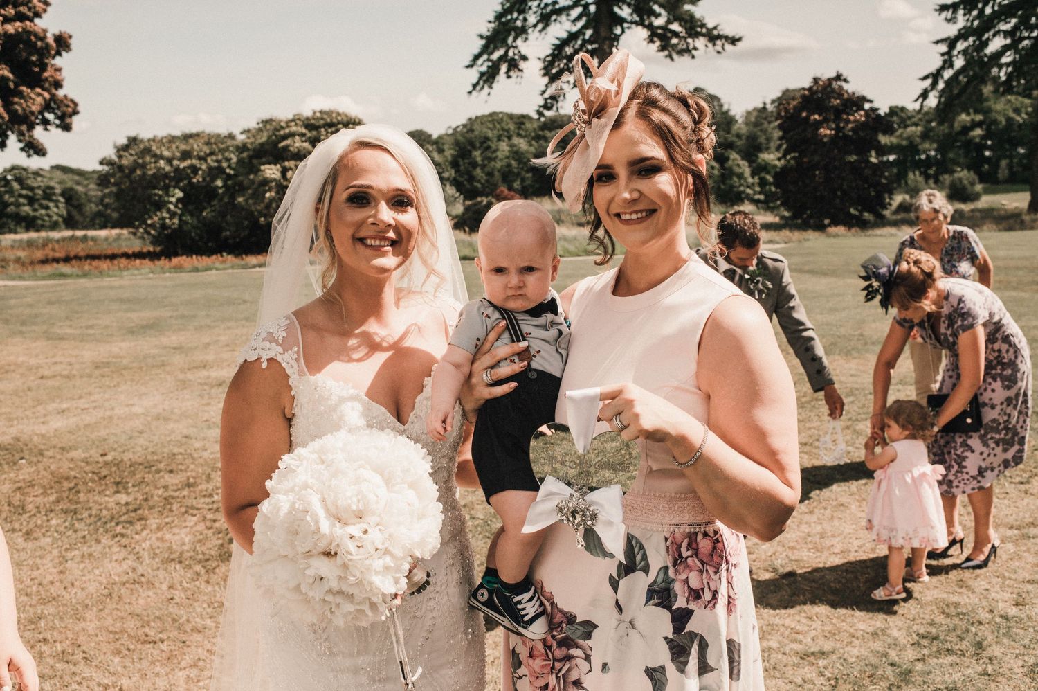 Beautiful outdoor wedding celebration with bridal bouquet and guests enjoying the sunshine.