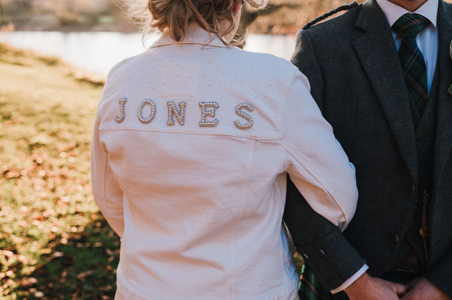 Close up of a white jacket with 'JONES' text embroidered on the back.