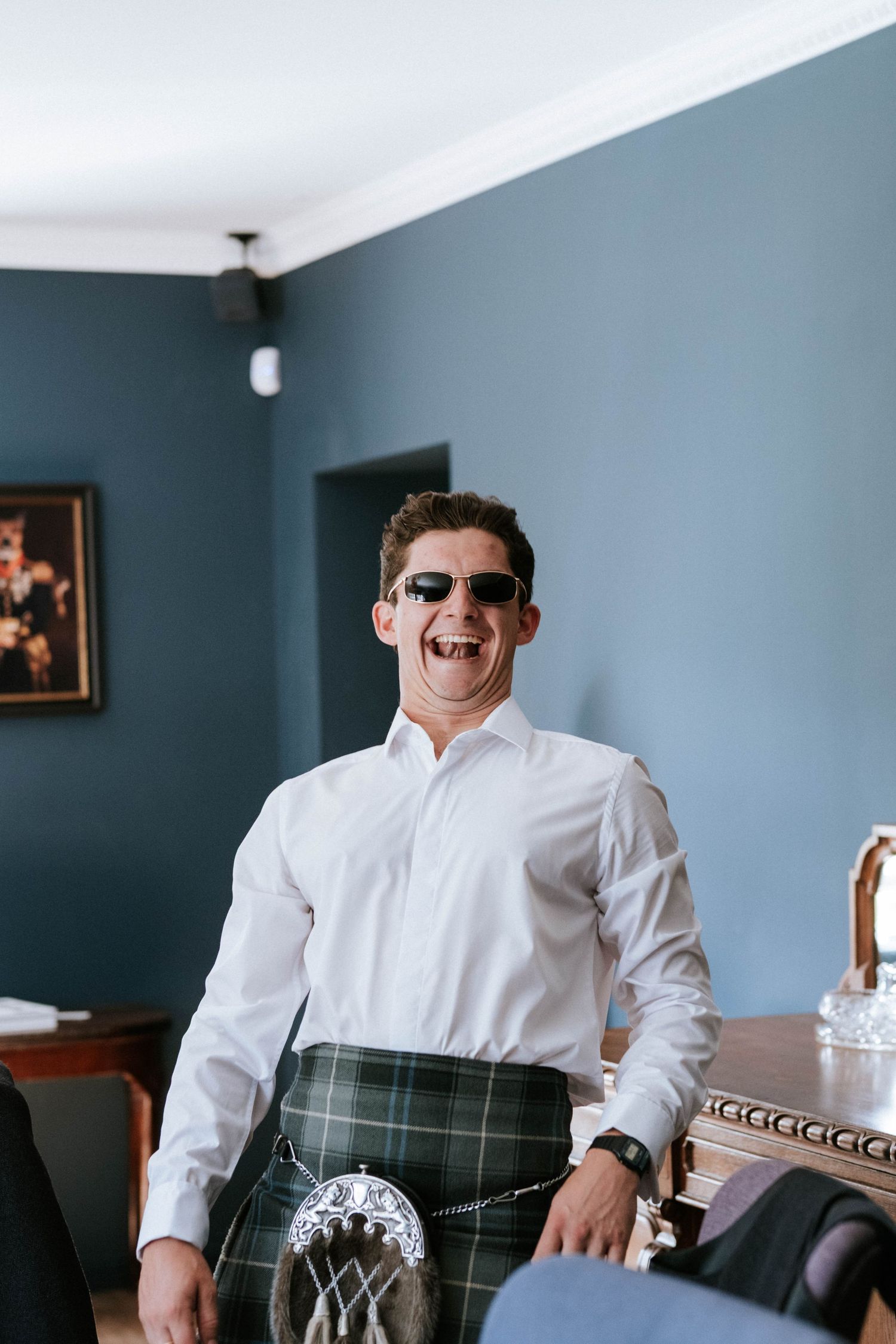 Traditional Scottish wedding attire featuring white shirt and tartan kilt.