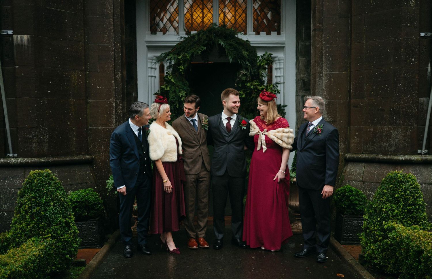 Drumtochty Castle  Wedding Photography. Wedding party gathered outside historic brick building with formal attire.