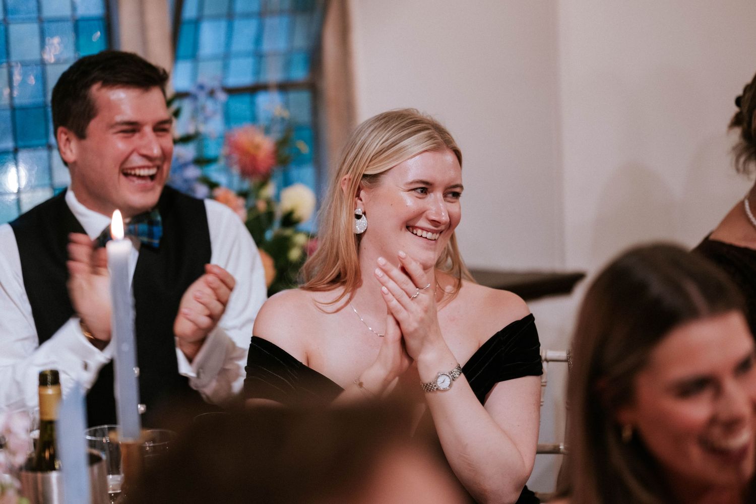 Joyful reactions from wedding guests during reception toasts and speeches.