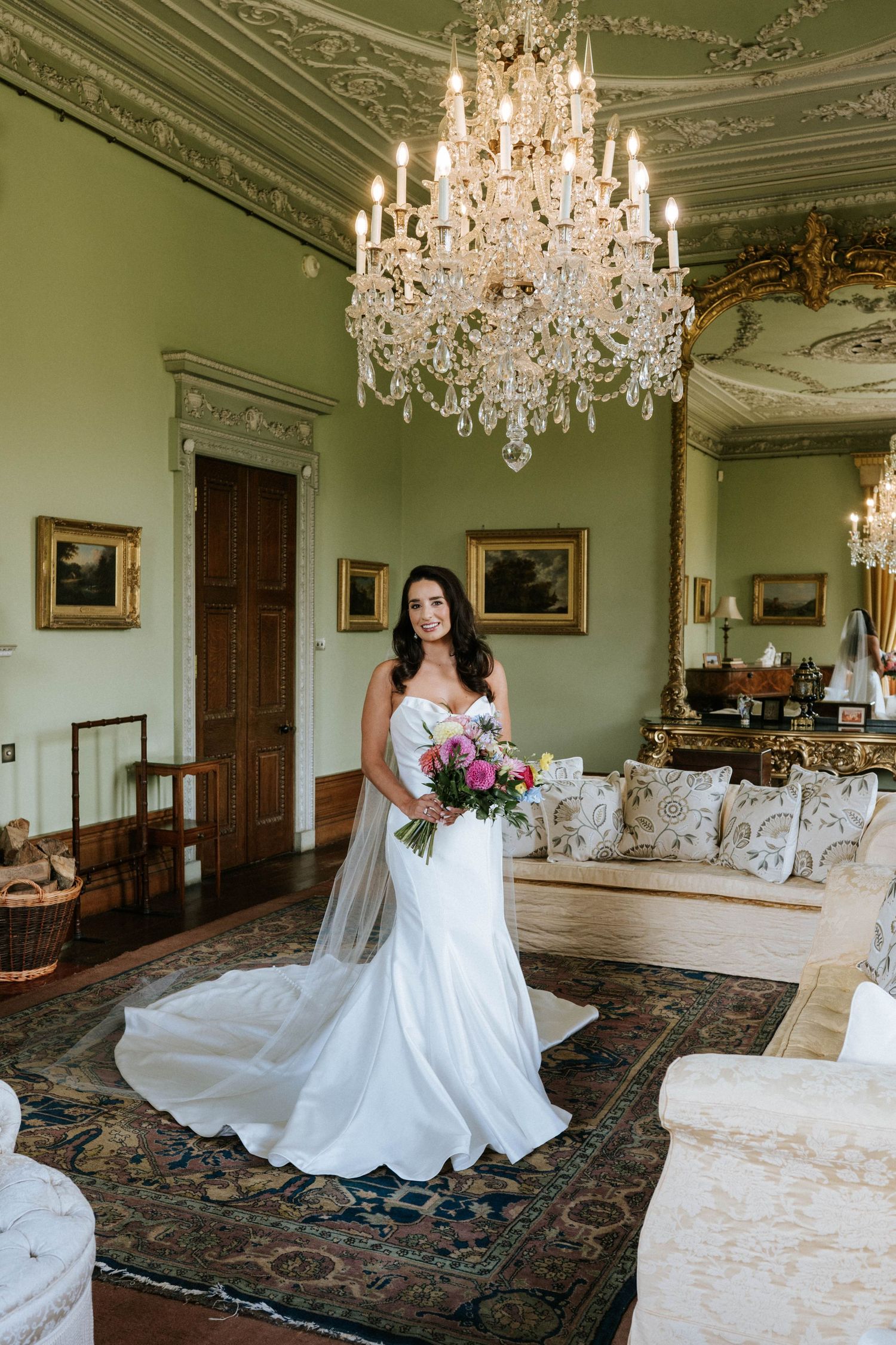 Aberdeen Wedding Photography. Elegant room with crystal chandelier and ornate moldings features white furniture and floral arrangements.