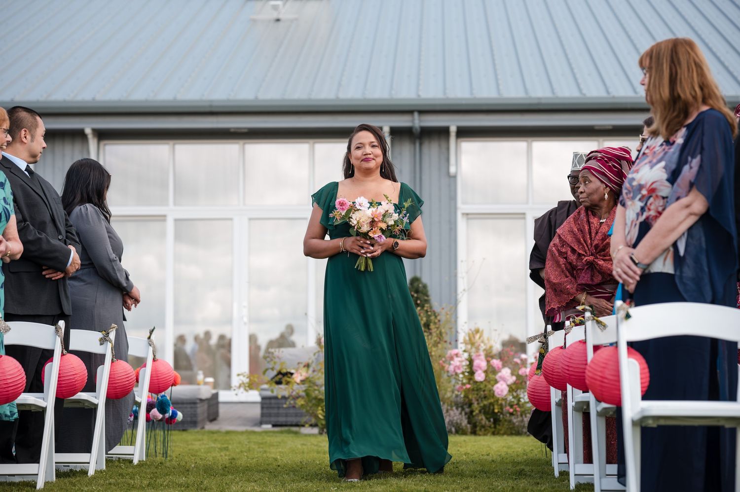 Guests mingling outside a white building during a celebration.