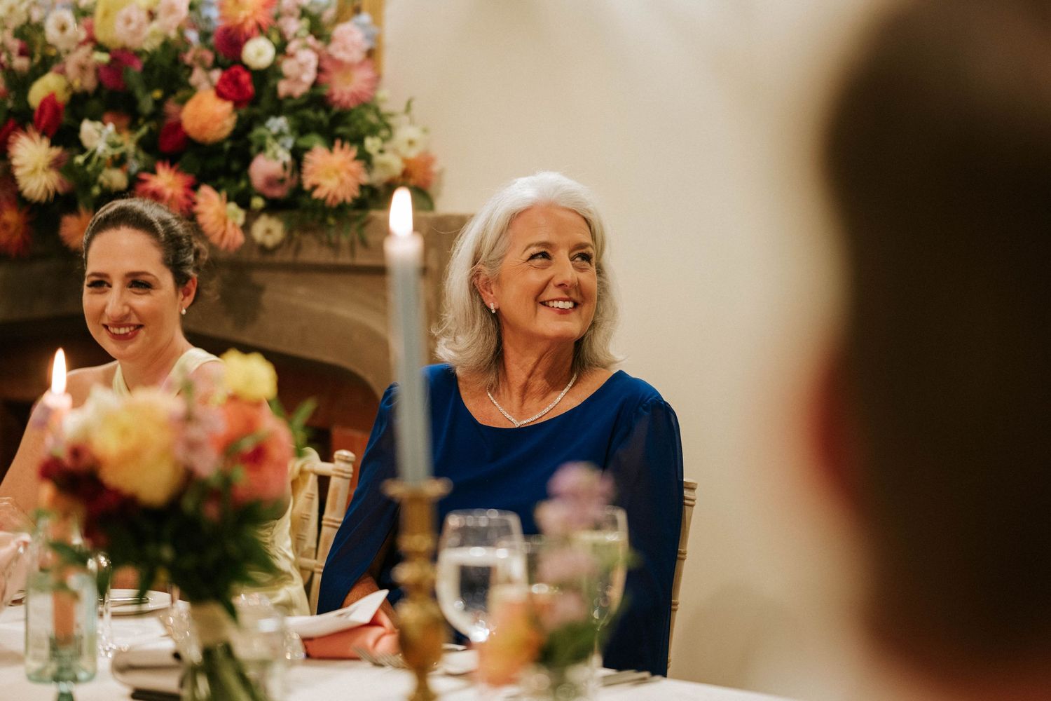 Elegant wedding reception table settings with colorful floral arrangements and candlelight.