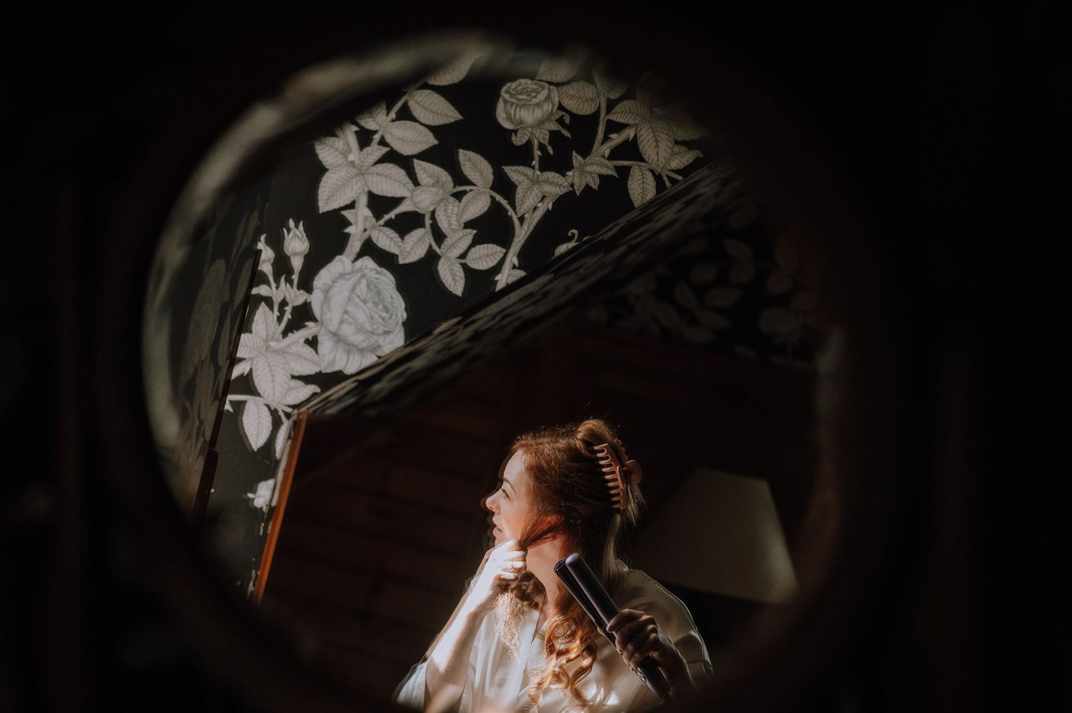Artistic framing through decorative mirror with floral details.