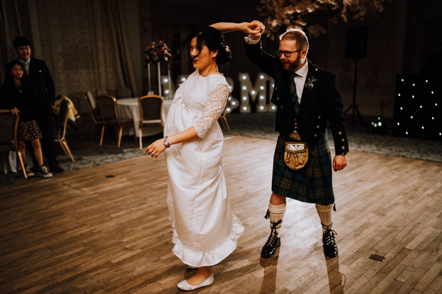 Wedding dance combines Scottish and Japanese traditions on elegant ballroom floor.