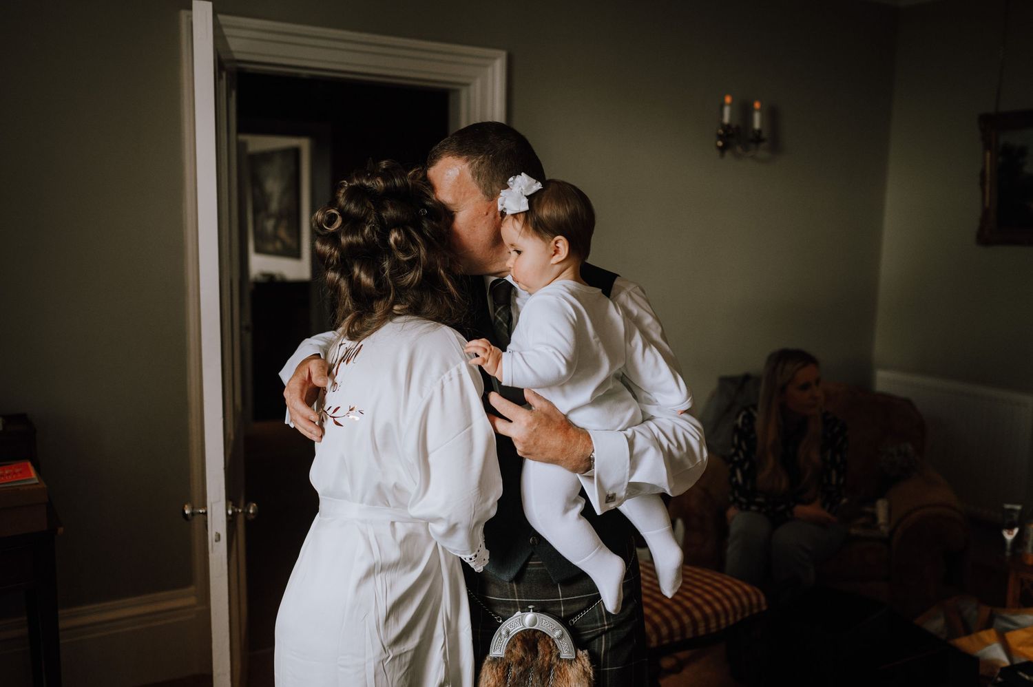 Wedding preparation moments show people in white robes sharing embraces.