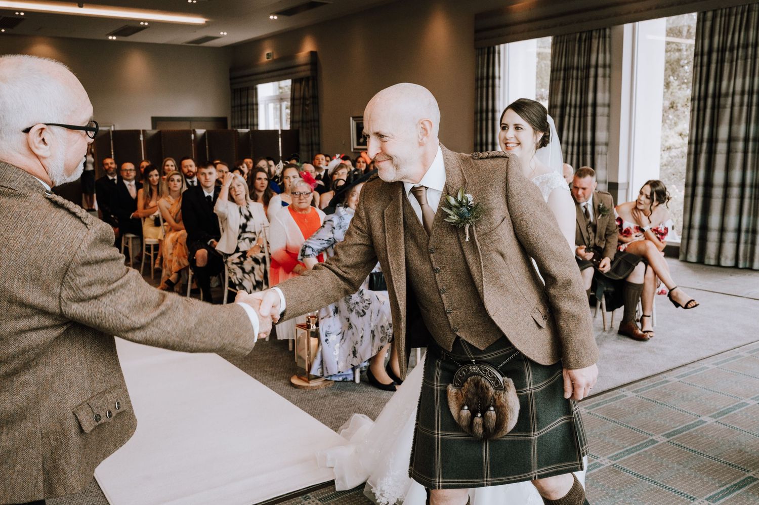 Two brides in white wedding dresses share a joyful moment during their ceremony.