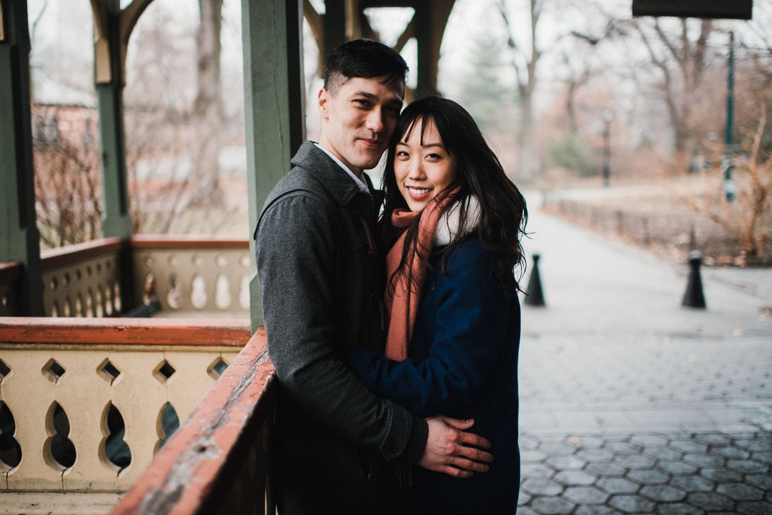 A couple shares an intimate moment on a decorative balcony during autumn.
