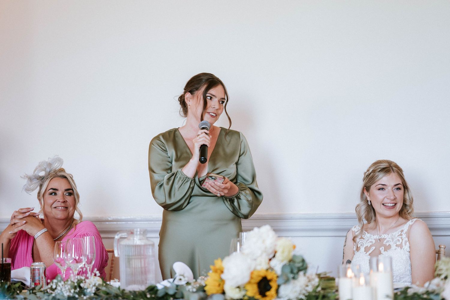 Emotional reactions during wedding speeches at an elegant reception with floral centerpieces.