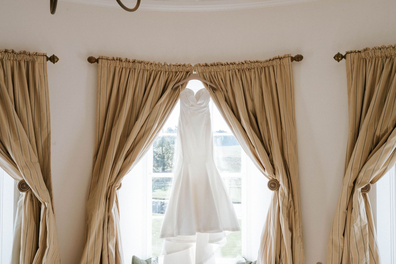Elegant room interior with beige curtains and decorative window treatments.