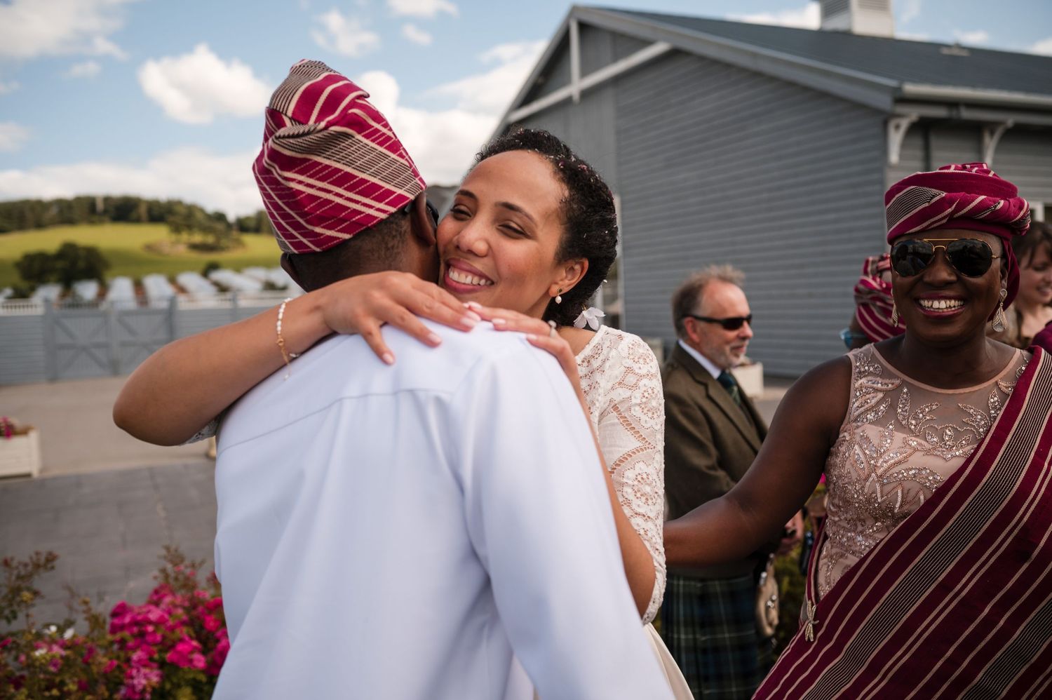 Emotional wedding celebration moments with guests embracing during an outdoor ceremony.