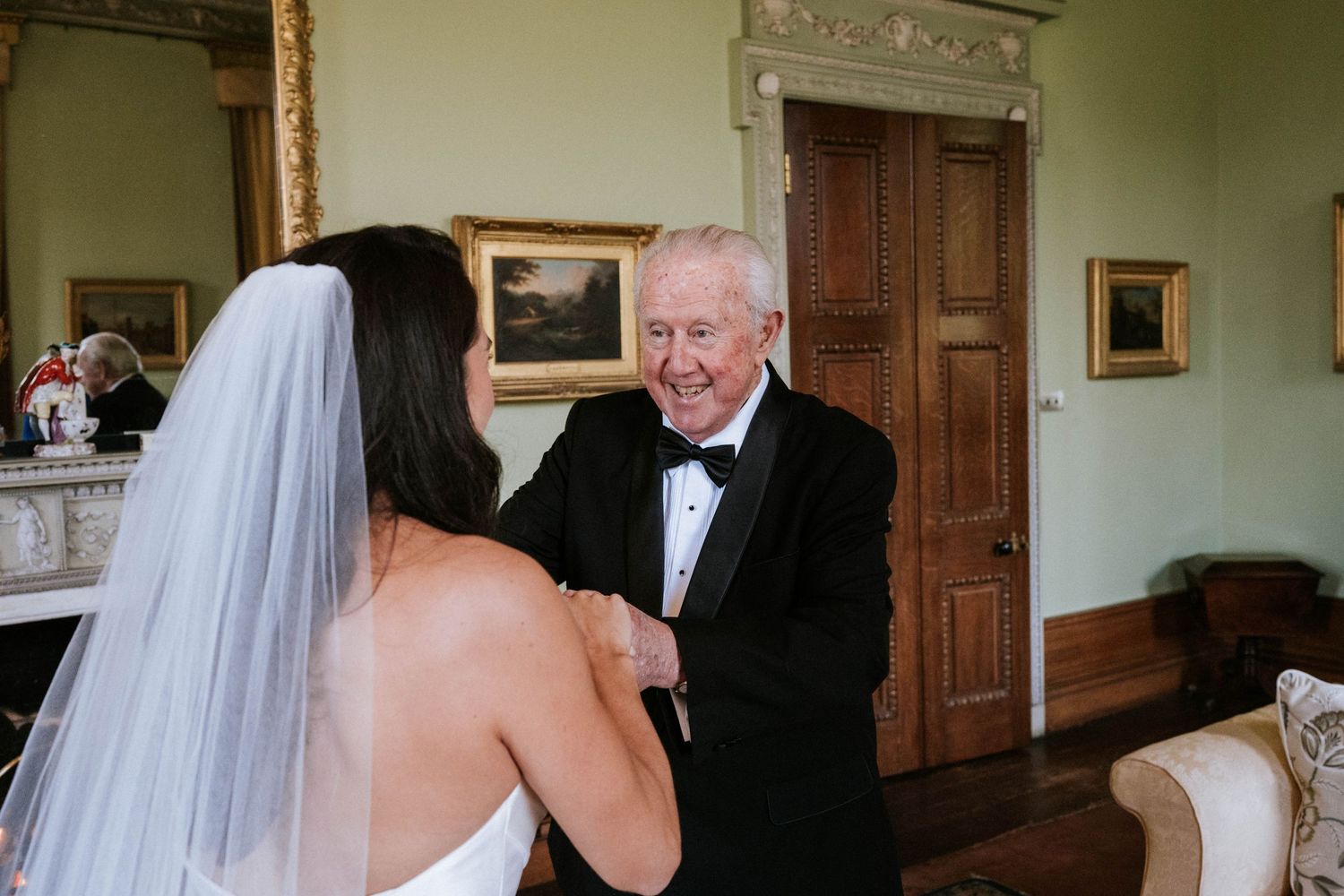 Wedding scene in an elegant room with traditional decor and wooden paneling.