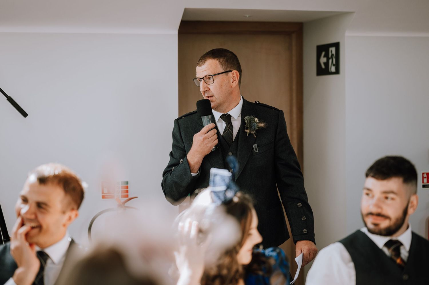 Guest delivers speech during wedding reception dinner.