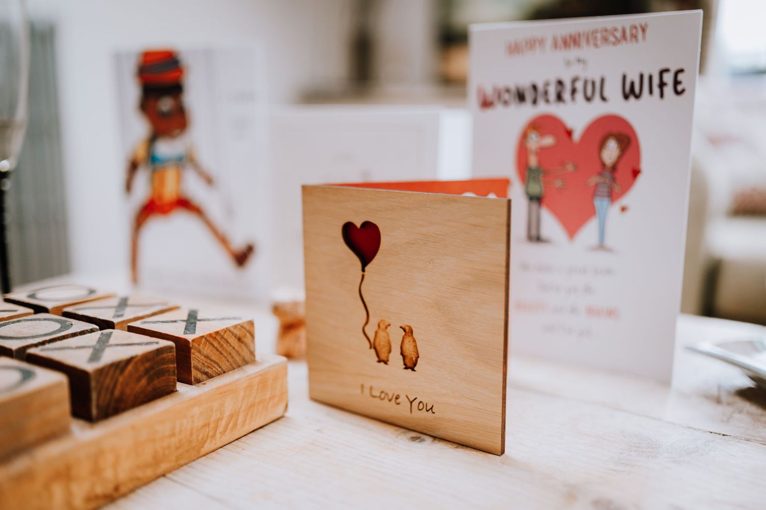 Wooden anniversary cards and decorative items arranged on white surface.