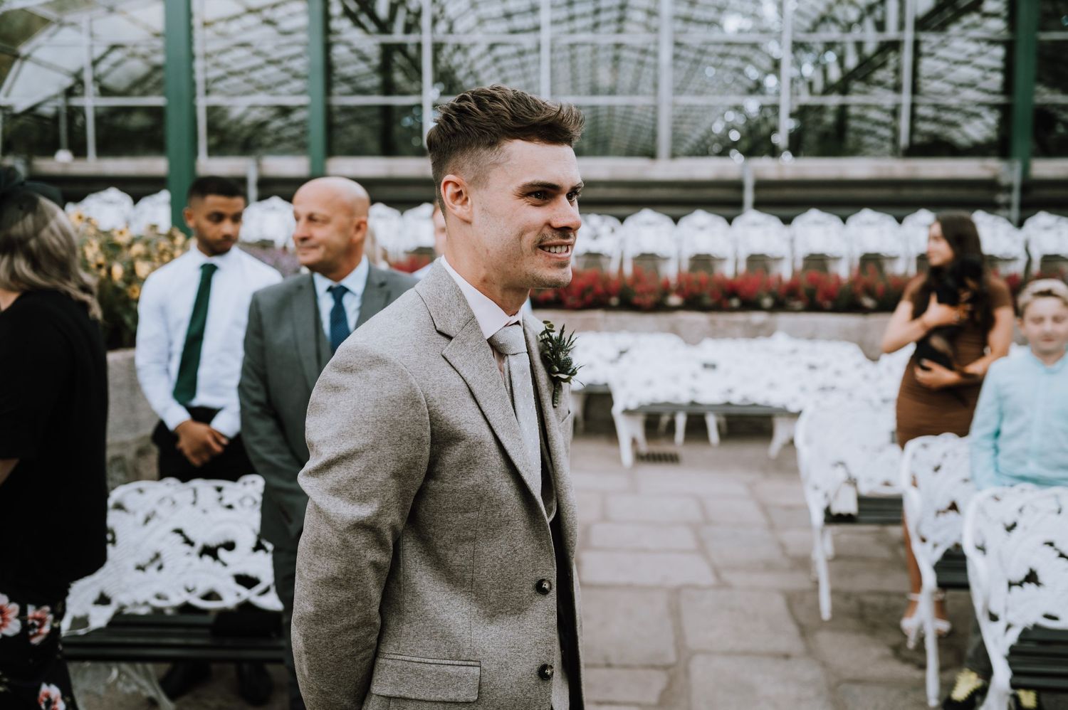 A greenhouse wedding ceremony setup with white chairs and elegant decor.