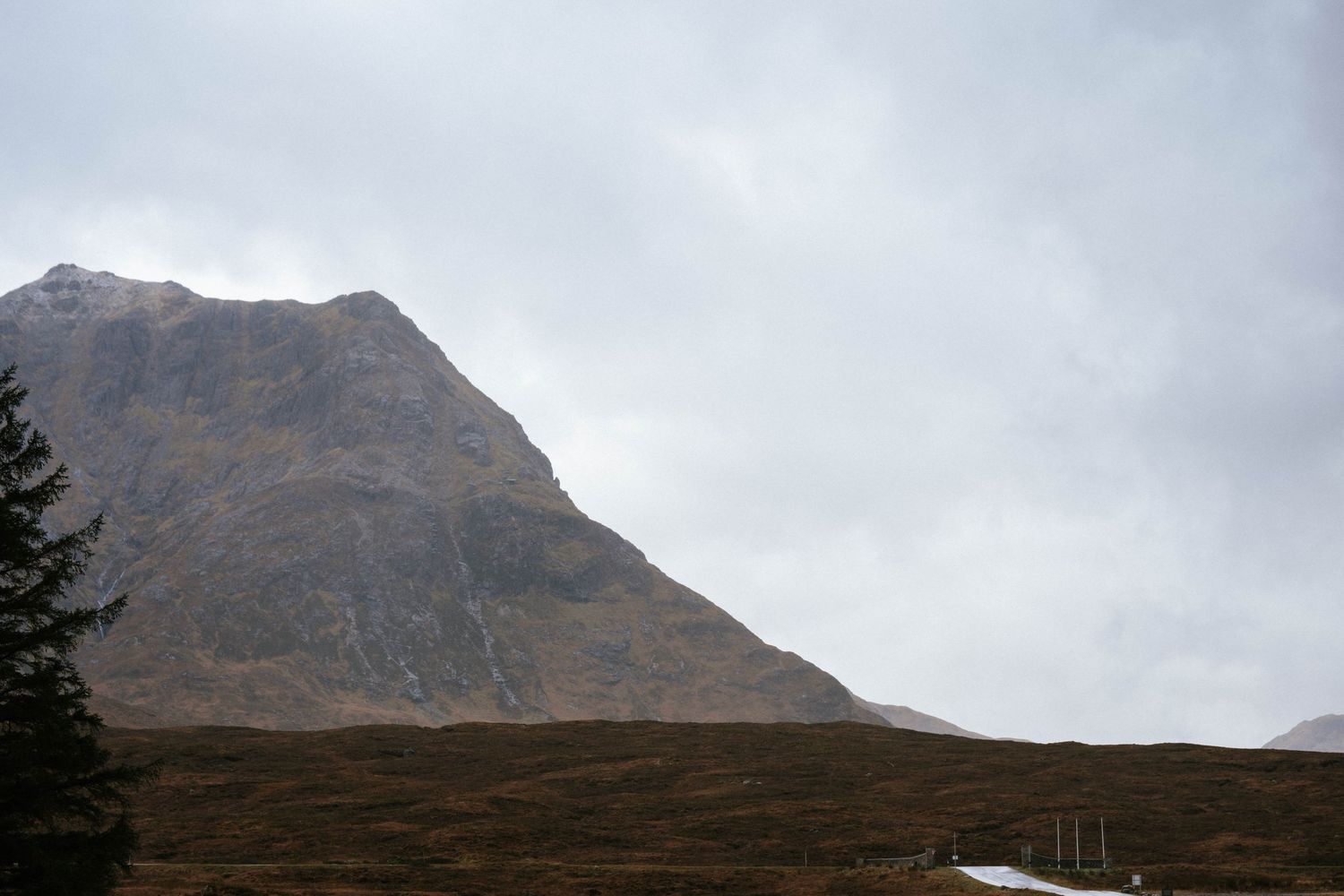 Misty mountain landscape with rugged peaks and cloudy Scottish highlands scenery.