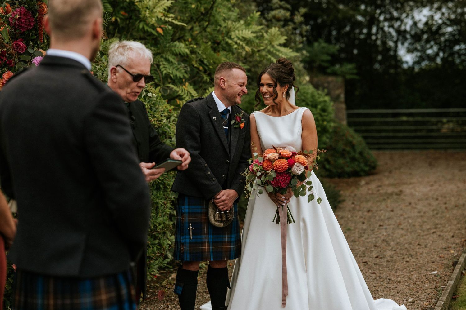 Outdoor wedding celebration with guests in formal attire.