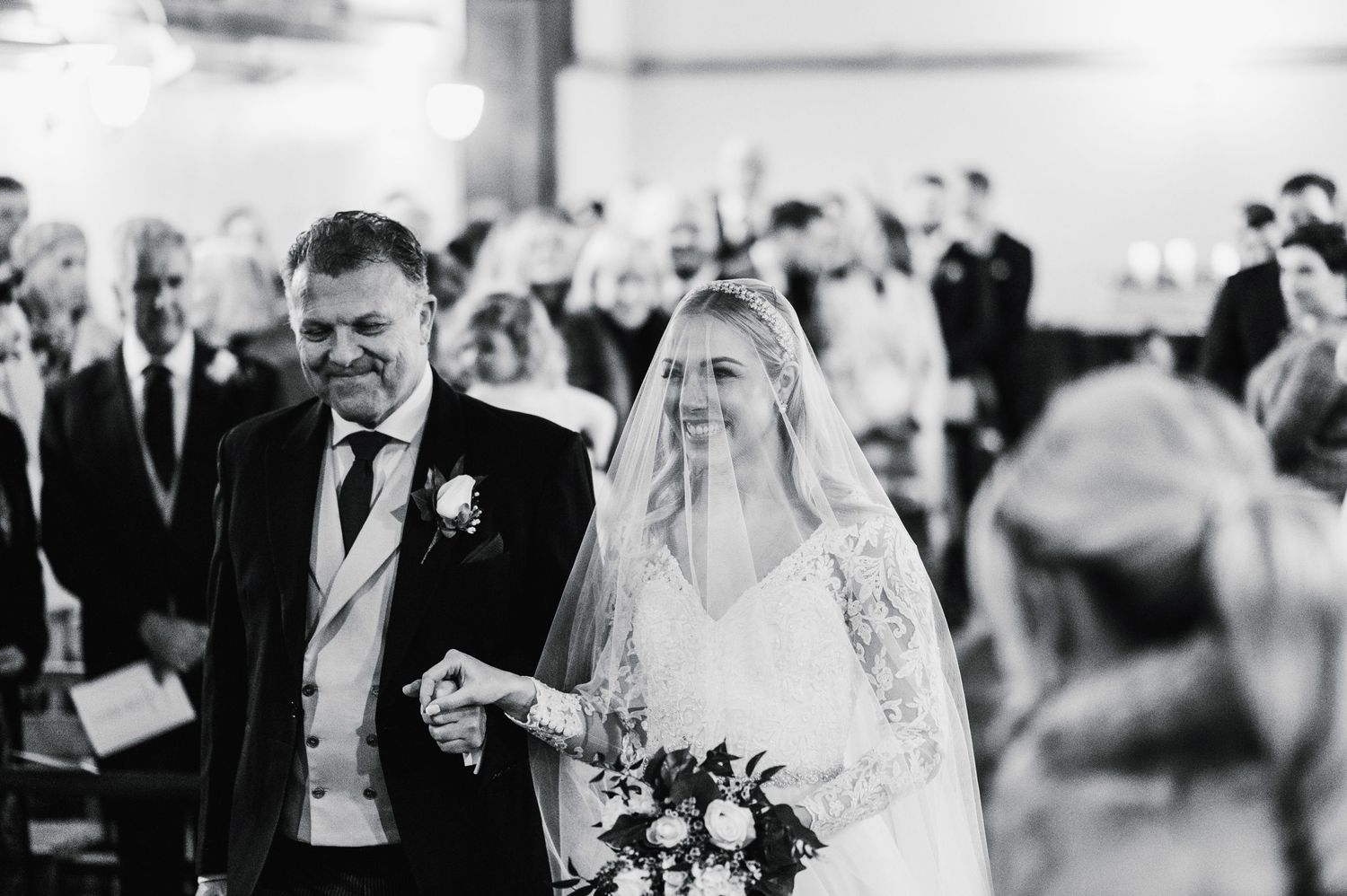 A black and white capture of a special moment during a wedding ceremony in a church setting.