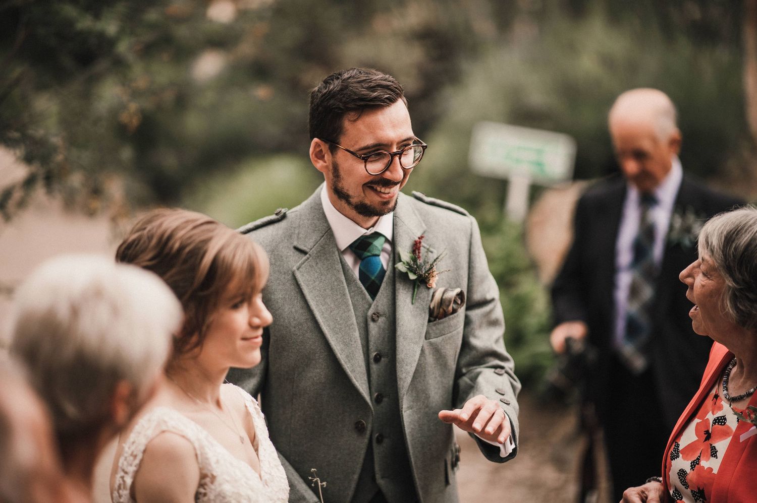 Candid moment at a Scottish wedding celebration with guests wearing traditional formal attire.