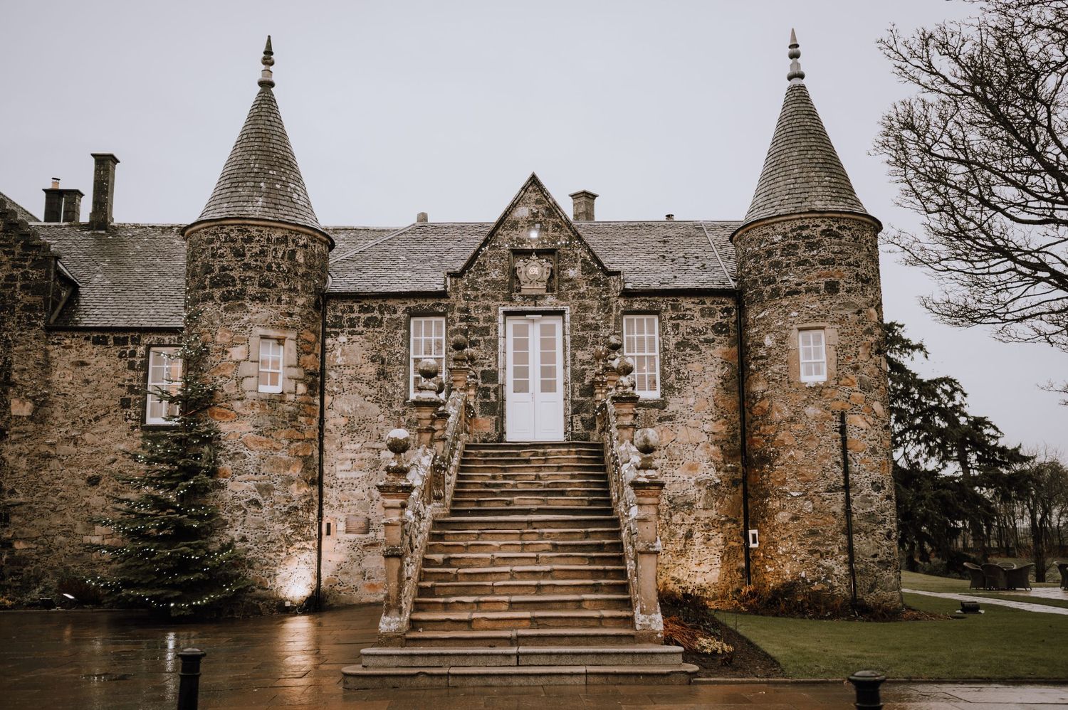 Gothic stone castle with twin spires and grand central staircase in Scotland.