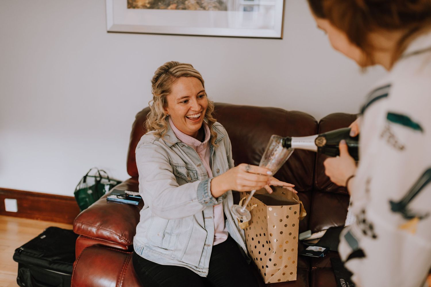 Wedding morning preparation scene in living room with leather couch.