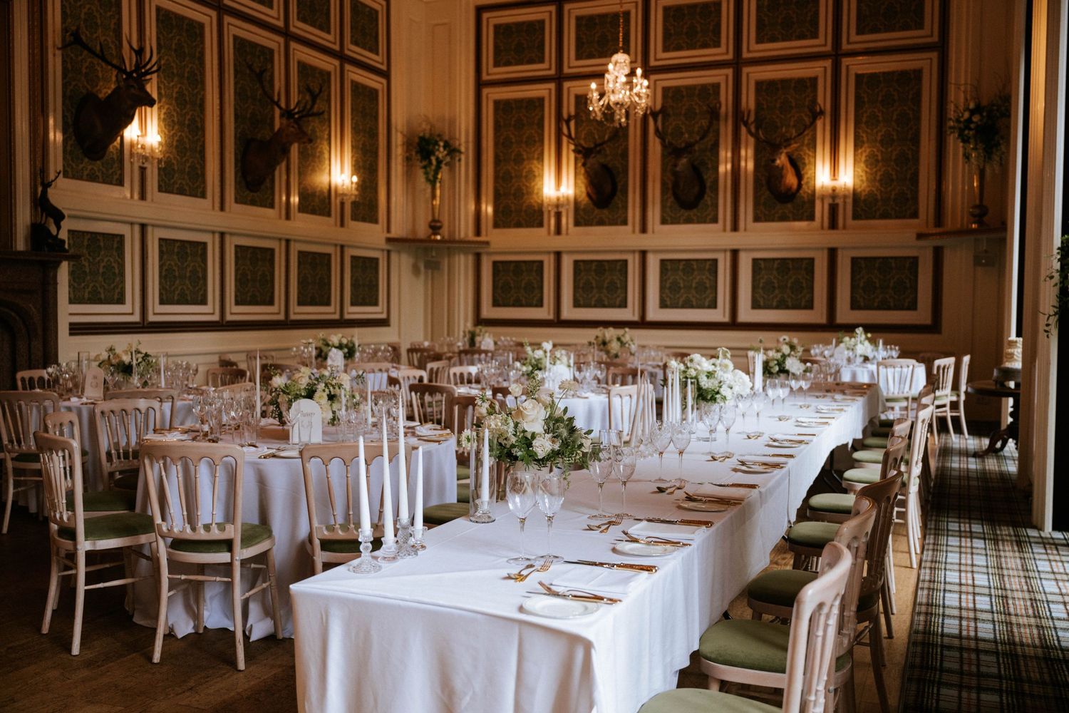 Elegant wedding reception hall set with round tables and classic white linens.