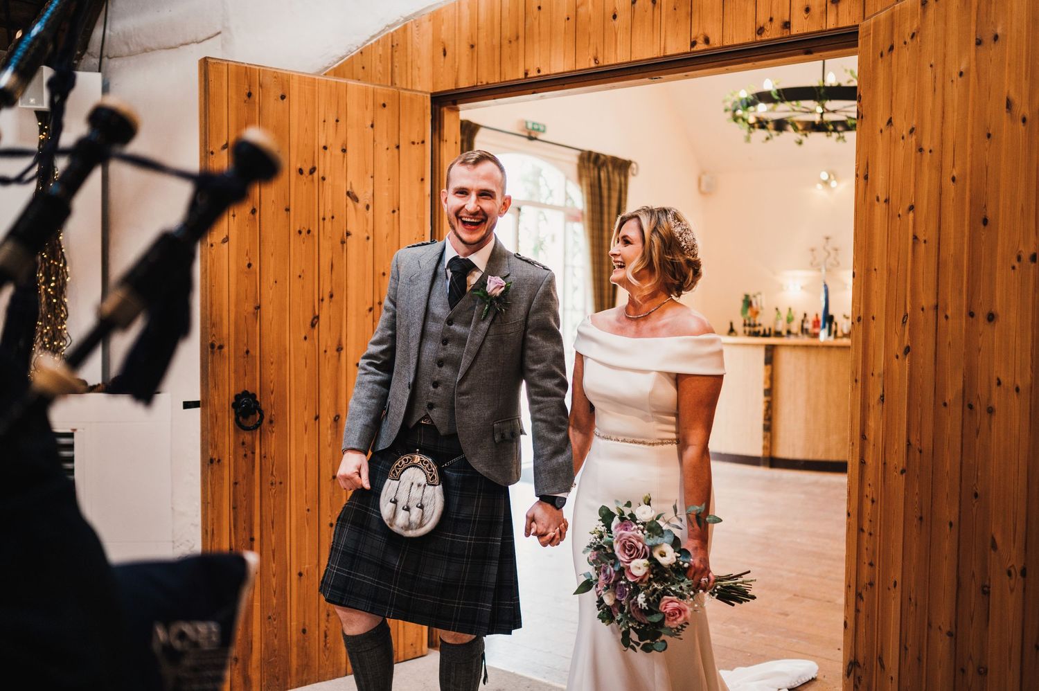 Wedding reception venue with rustic wooden walls and decorative lighting.
